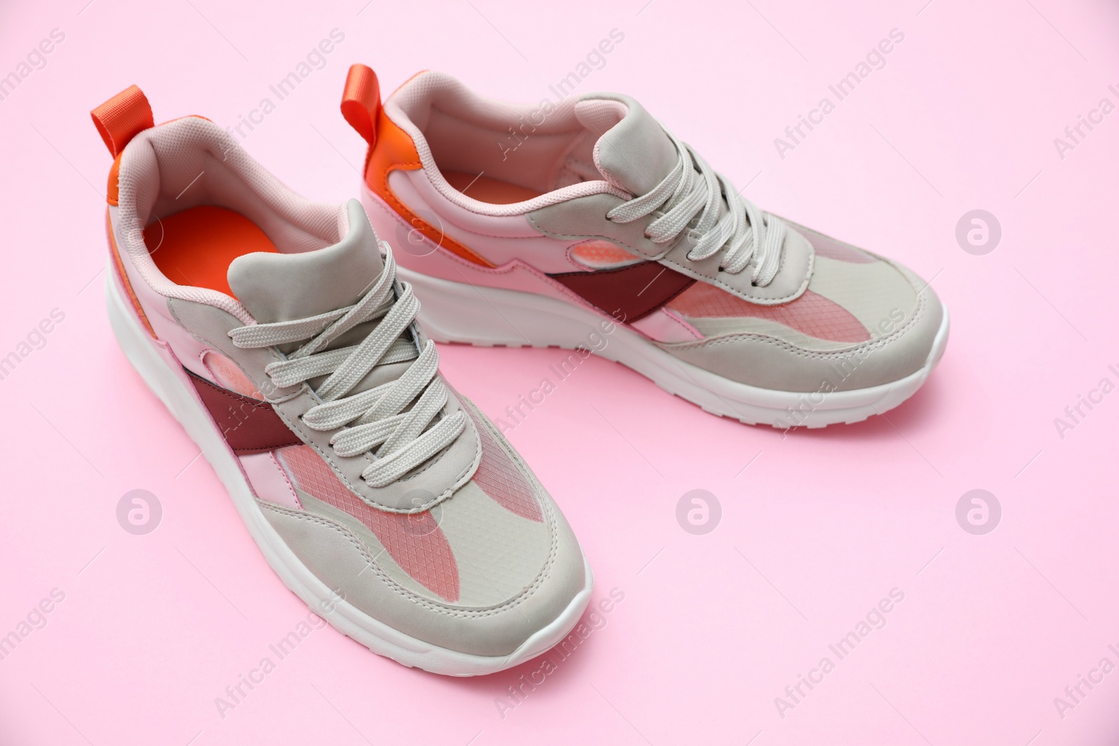 Photo of Pair of stylish women's sneakers on pink background