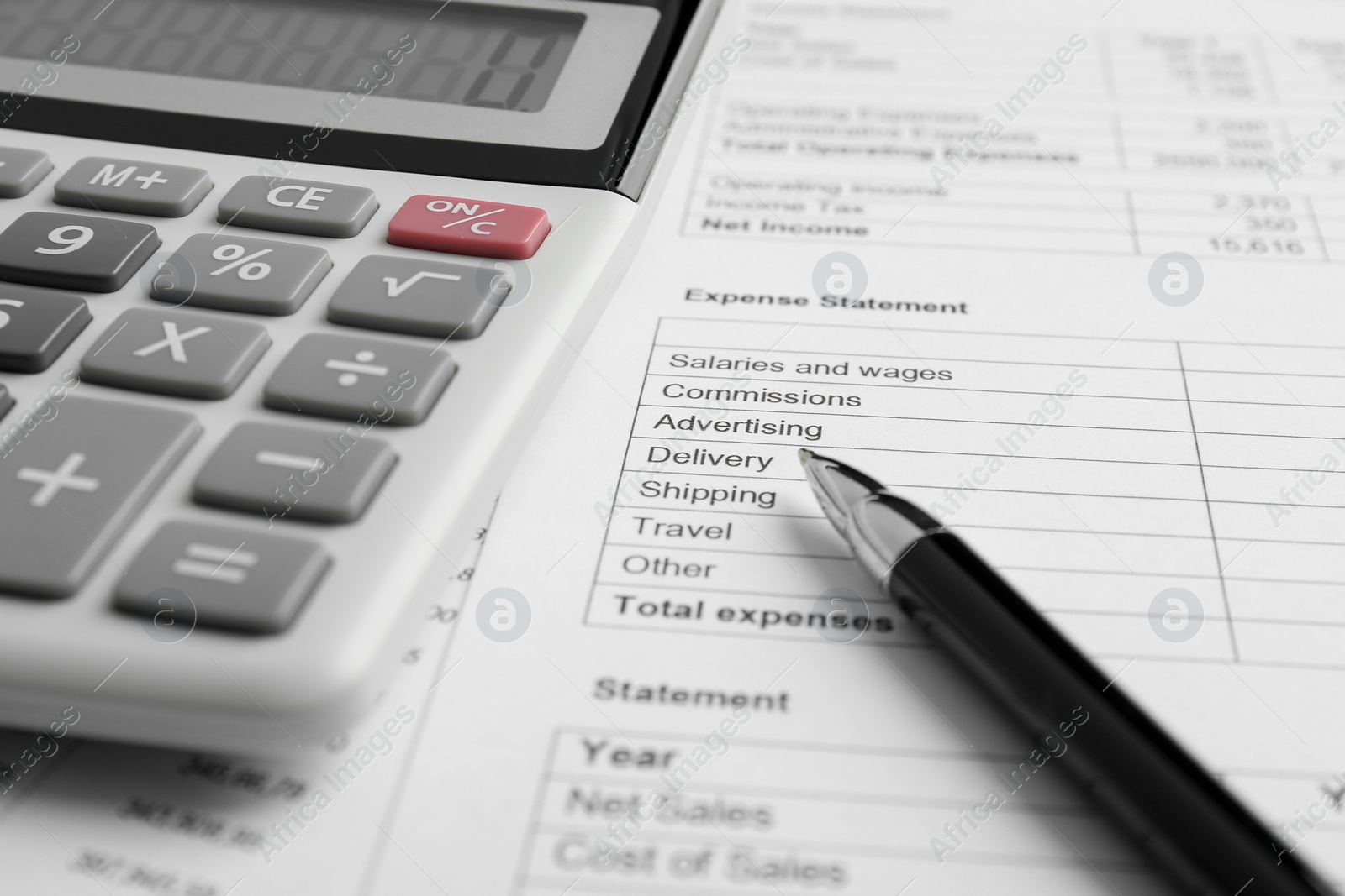 Photo of Calculator and pen on documents, closeup view