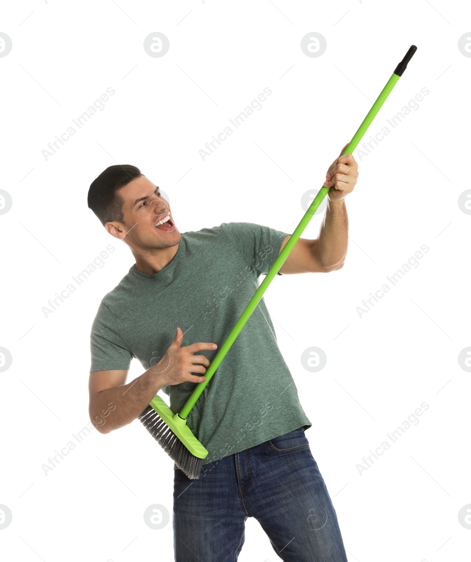 Photo of Man with green broom having fun on white background