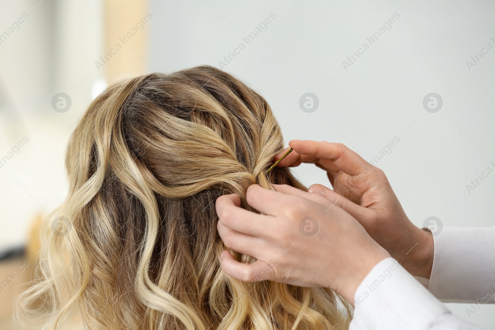 Photo of Hair styling. Professional hairdresser working with client indoors, closeup