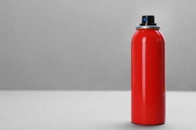 Bottle with insect repellent spray on grey background, space for text