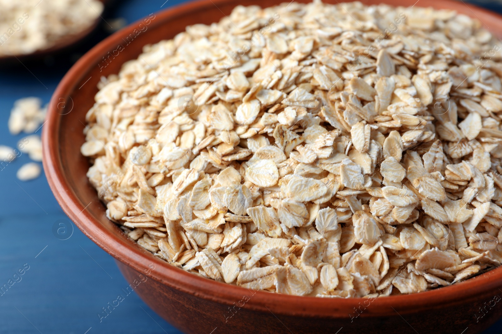 Photo of Bowl of oatmeal on blue table, closeup