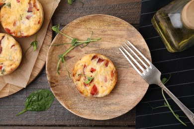 Delicious egg muffins with cheese and bacon on wooden table, flat lay