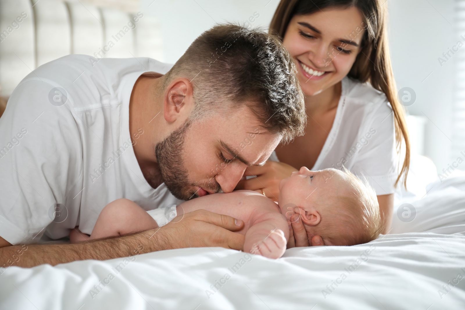 Photo of Happy couple with their newborn baby at home