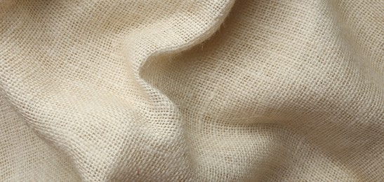 Texture of beige crumpled fabric as background, top view