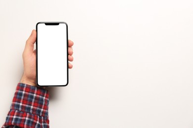 Man with smartphone on white background, top view. Space for text