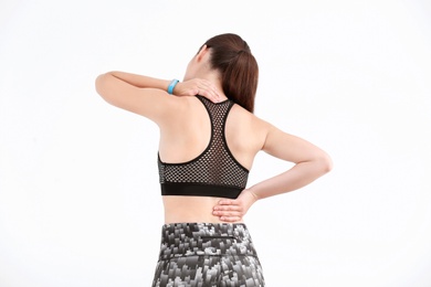 Photo of Woman in sportswear suffering from back pain on white background