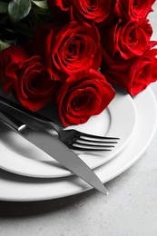 Photo of Romantic table setting with rose flowers, closeup