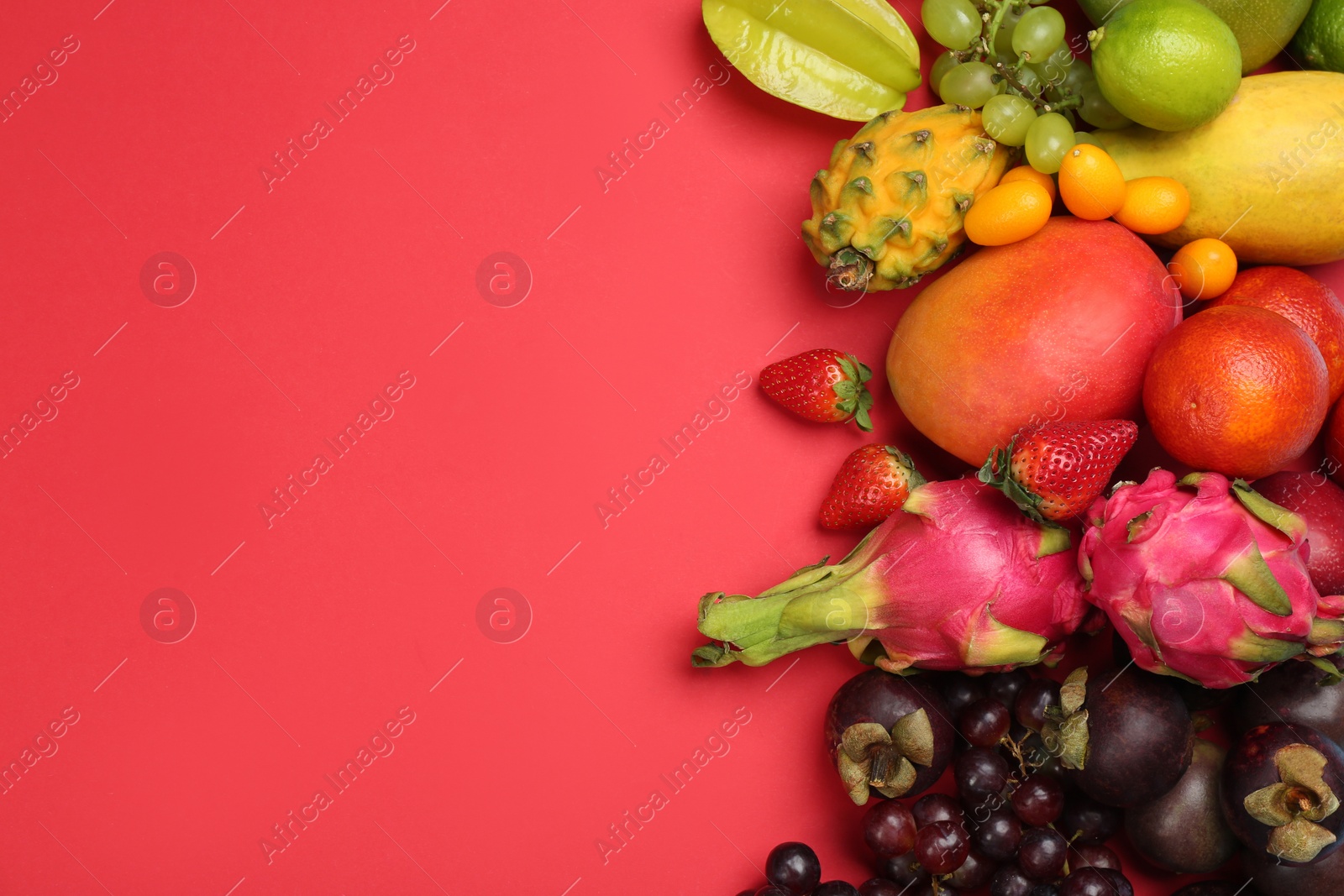 Photo of Many different delicious exotic fruits on red background, flat lay. Space for text