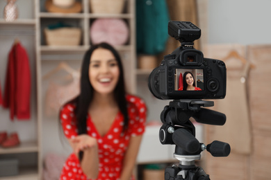 Fashion blogger recording new video in room, focus on camera