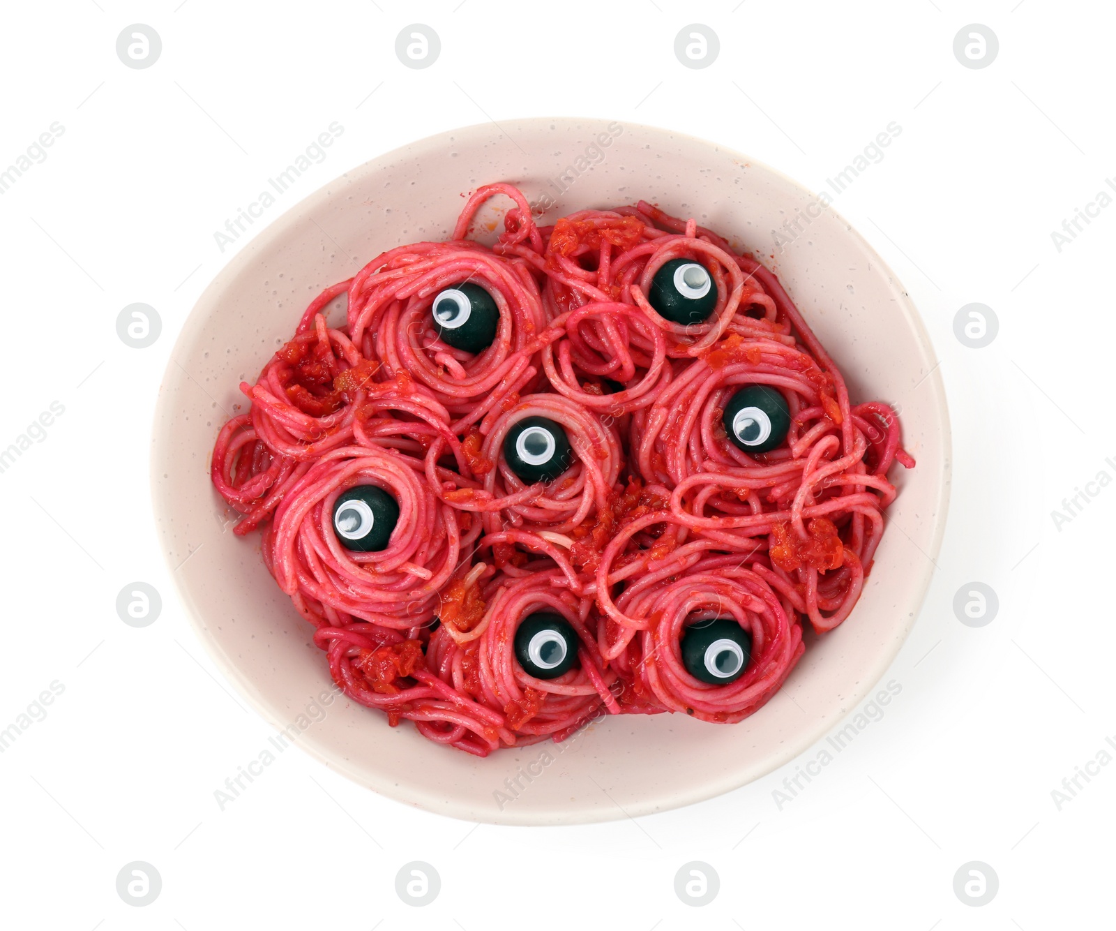 Photo of Red pasta with decorative eyes and olives in bowl isolated on white, top view. Halloween food