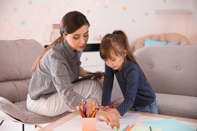 Female psychologist working with cute little girl in office