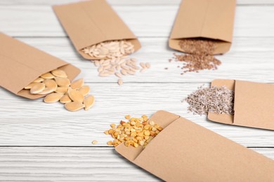 Photo of Many different vegetable seeds on white wooden table