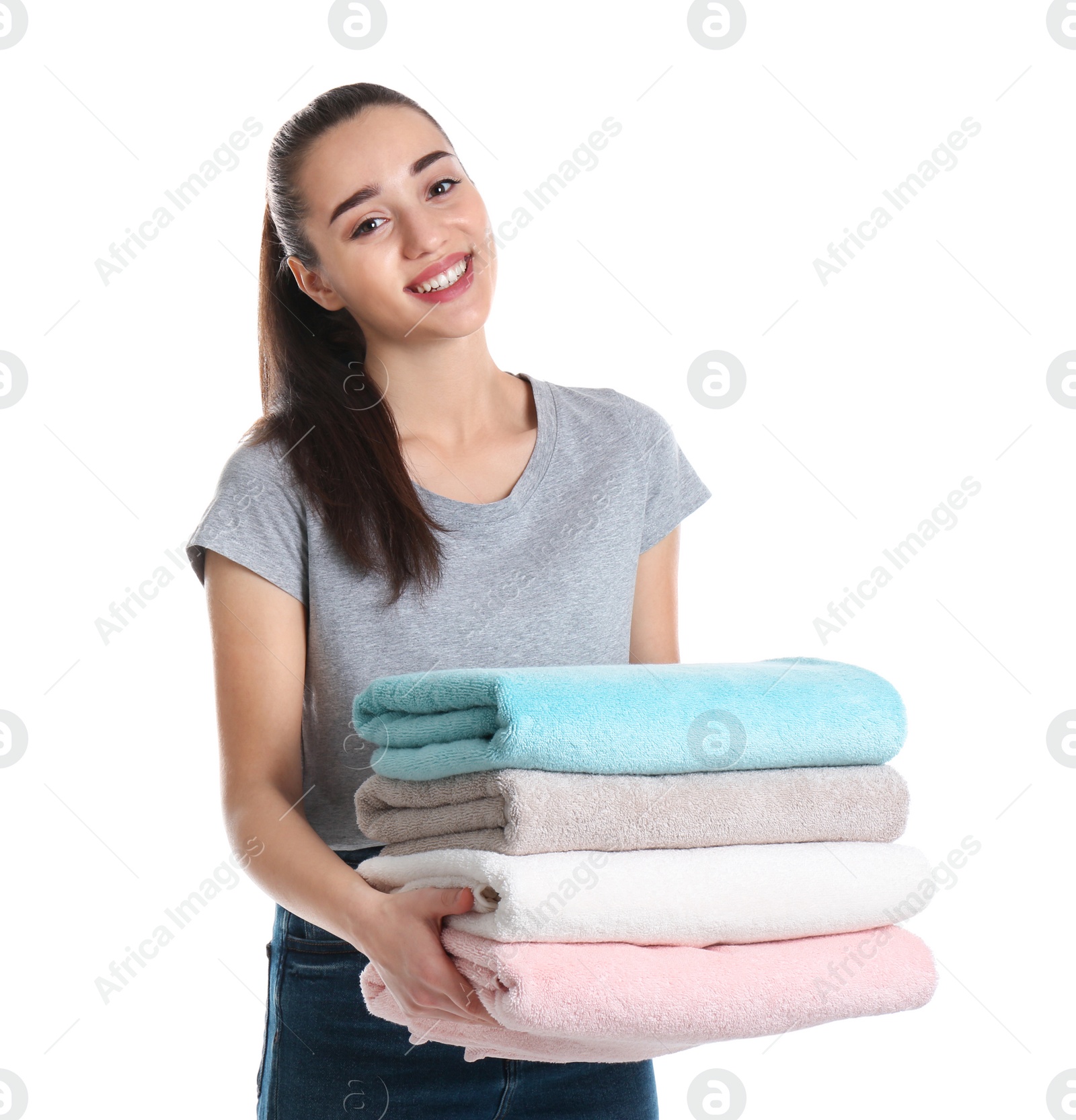 Photo of Happy young woman holding clean towels on white background. Laundry day