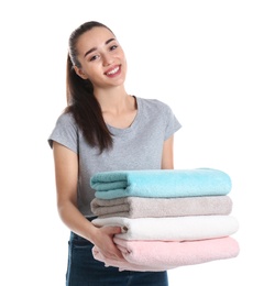 Happy young woman holding clean towels on white background. Laundry day