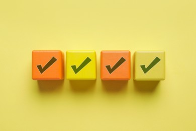 Image of Cubes with check marks on yellow background, top view
