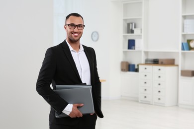 Photo of Smiling young businessman with folders in office. Space for text