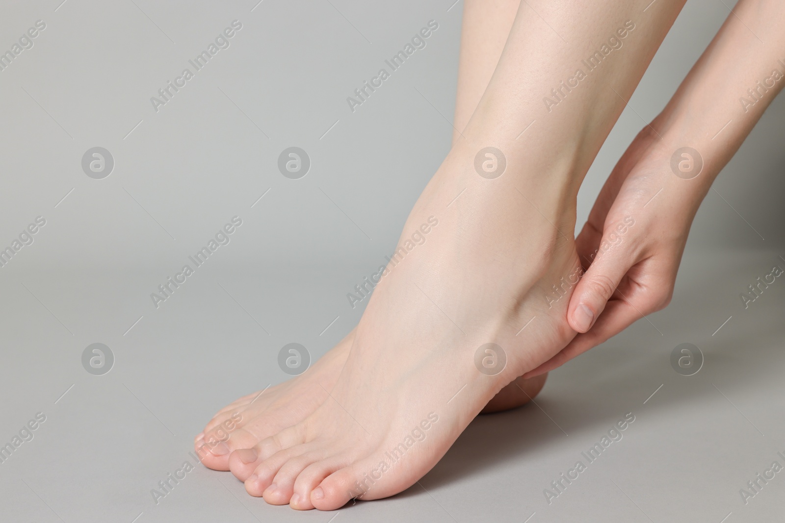 Photo of Closeup view of woman`s groomed feet after care procedure on grey background