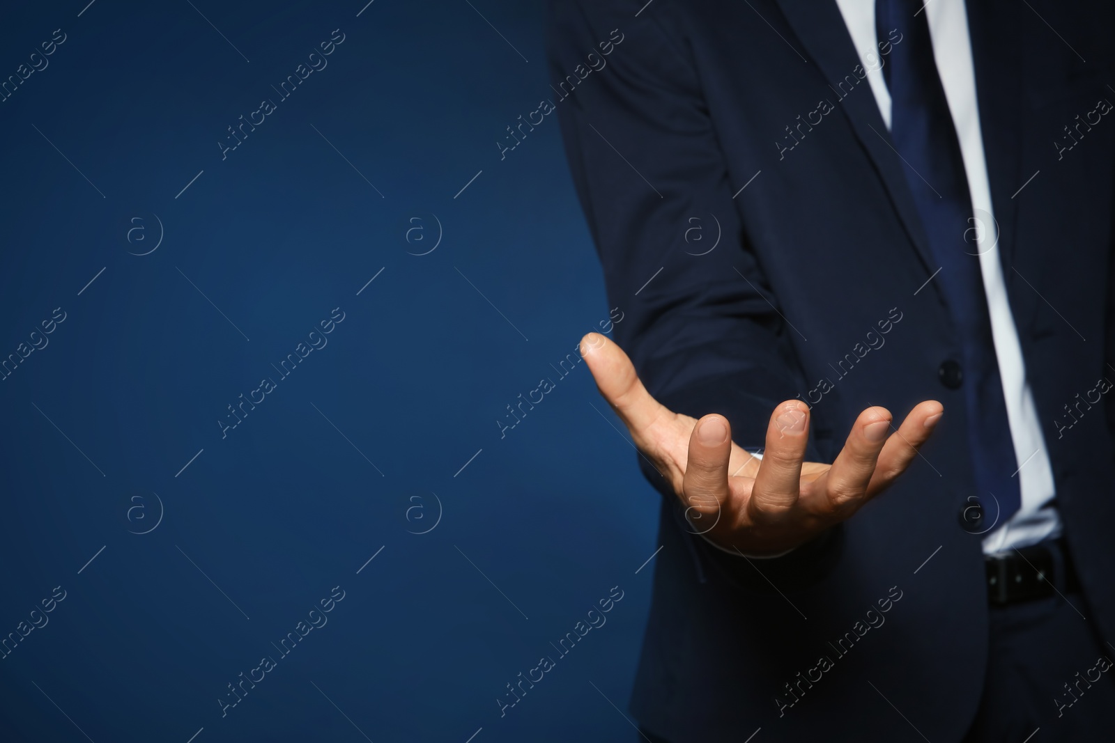 Photo of Businessman holding something on color background, closeup view of hand with space for text