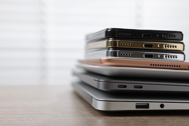 Photo of Many different modern gadgets on wooden table indoors, closeup. Space for text