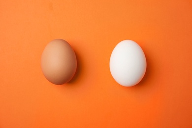 Photo of Raw chicken eggs on color background, top view