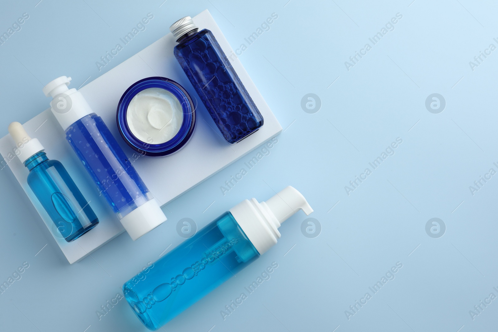 Photo of Set of cosmetic products on light blue background, flat lay. Space for text