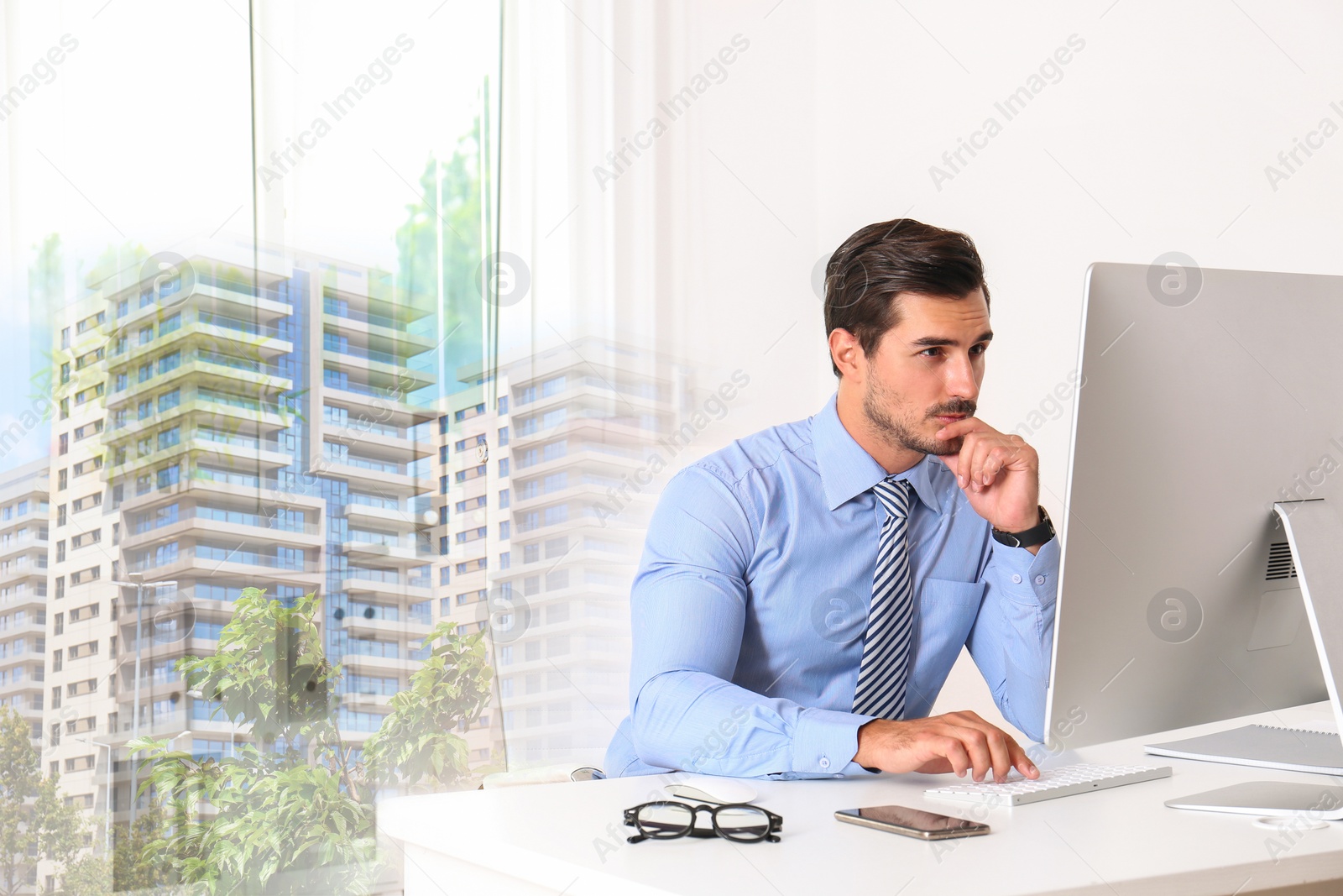 Image of Engineer working with computer at table in office and buildings. Double exposure