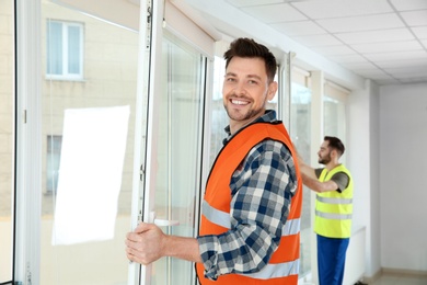 Photo of Construction workers installing plastic windows in house