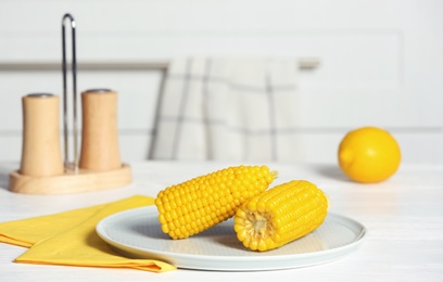 Plate with ripe corn cobs on table