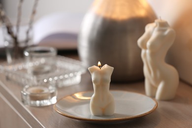 Photo of Beautiful body shaped candles on table indoors