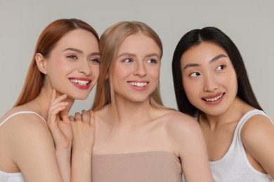 Portrait of beautiful young women on light grey background