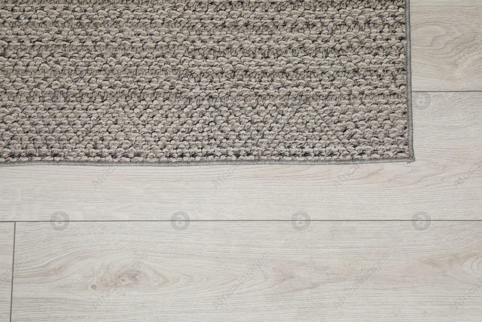 Photo of Soft grey carpet on white laminated floor indoors, top view. Space for text