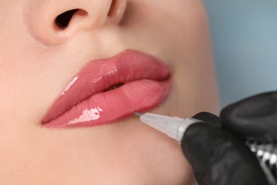 Photo of Young woman during procedure of permanent lip makeup in beauty salon, closeup