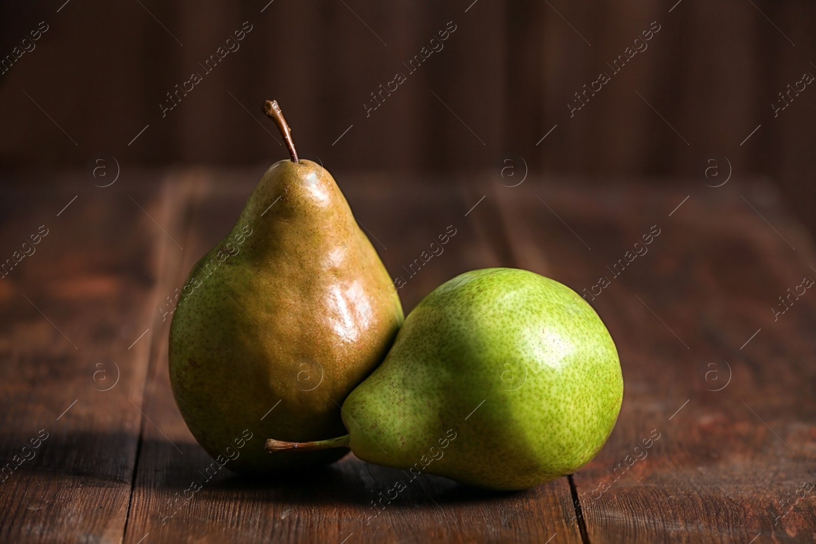 Photo of Tasty ripe pears on rustic wooden background