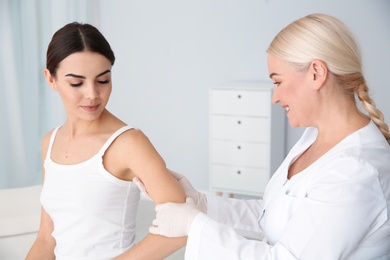 Photo of Dermatologist examining young patient's birthmark in clinic