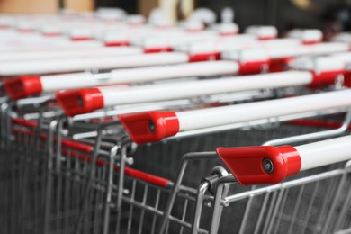 Photo of Many empty metal shopping carts, closeup view