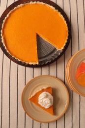 Photo of Fresh homemade pumpkin pie with whipped cream on table, flat lay