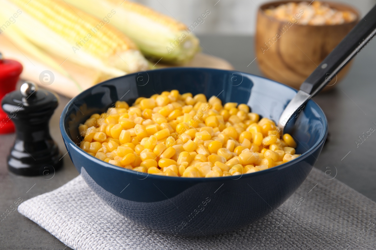 Photo of Bowl with corn kernels on grey table