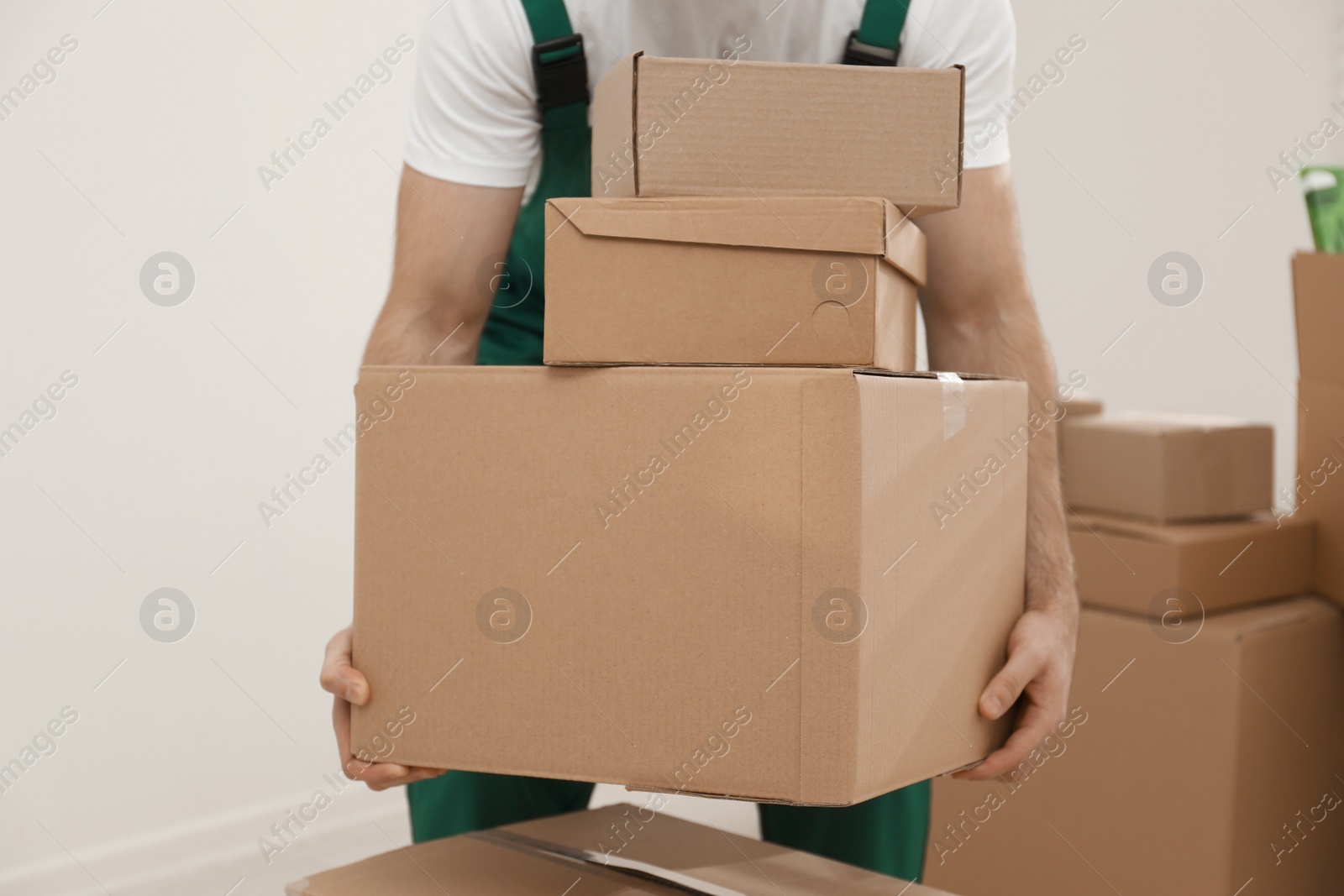 Photo of Man with cardboard boxes in room, closeup. Moving service