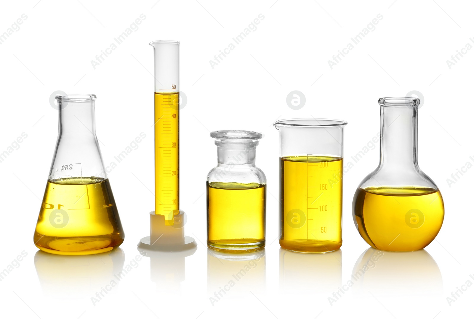 Photo of Laboratory glassware with yellow liquid on white background