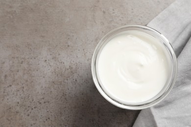 Photo of Jar with delicious organic yogurt on grey table, top view. Space for text