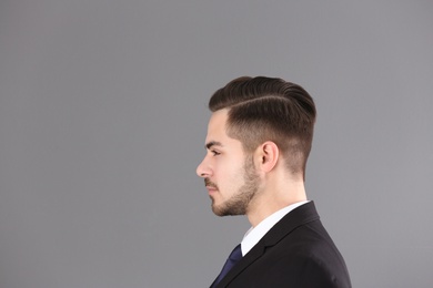 Portrait of young man with beautiful hair on grey background