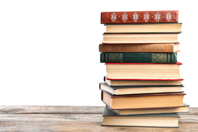 Stack of old vintage books on wooden table against white background