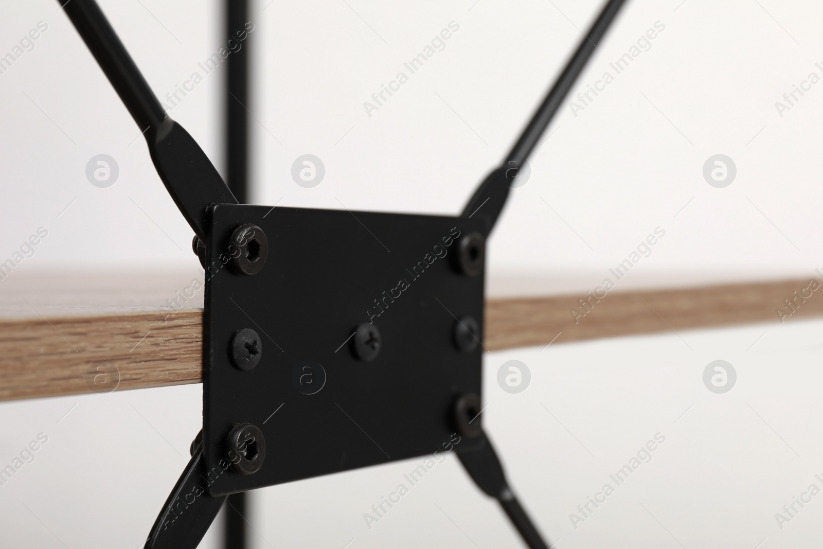 Photo of Rack with black metal connecting detail on light background, closeup