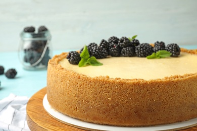 Photo of Delicious cheesecake decorated with blackberries on table