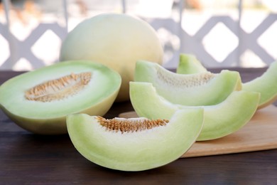 Photo of Cut tasty ripe melon on wooden table