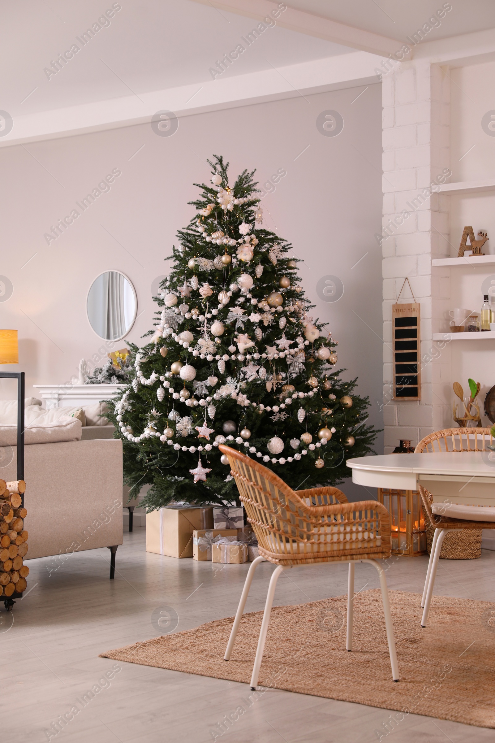 Photo of Cozy dining room interior with Christmas tree and festive decor