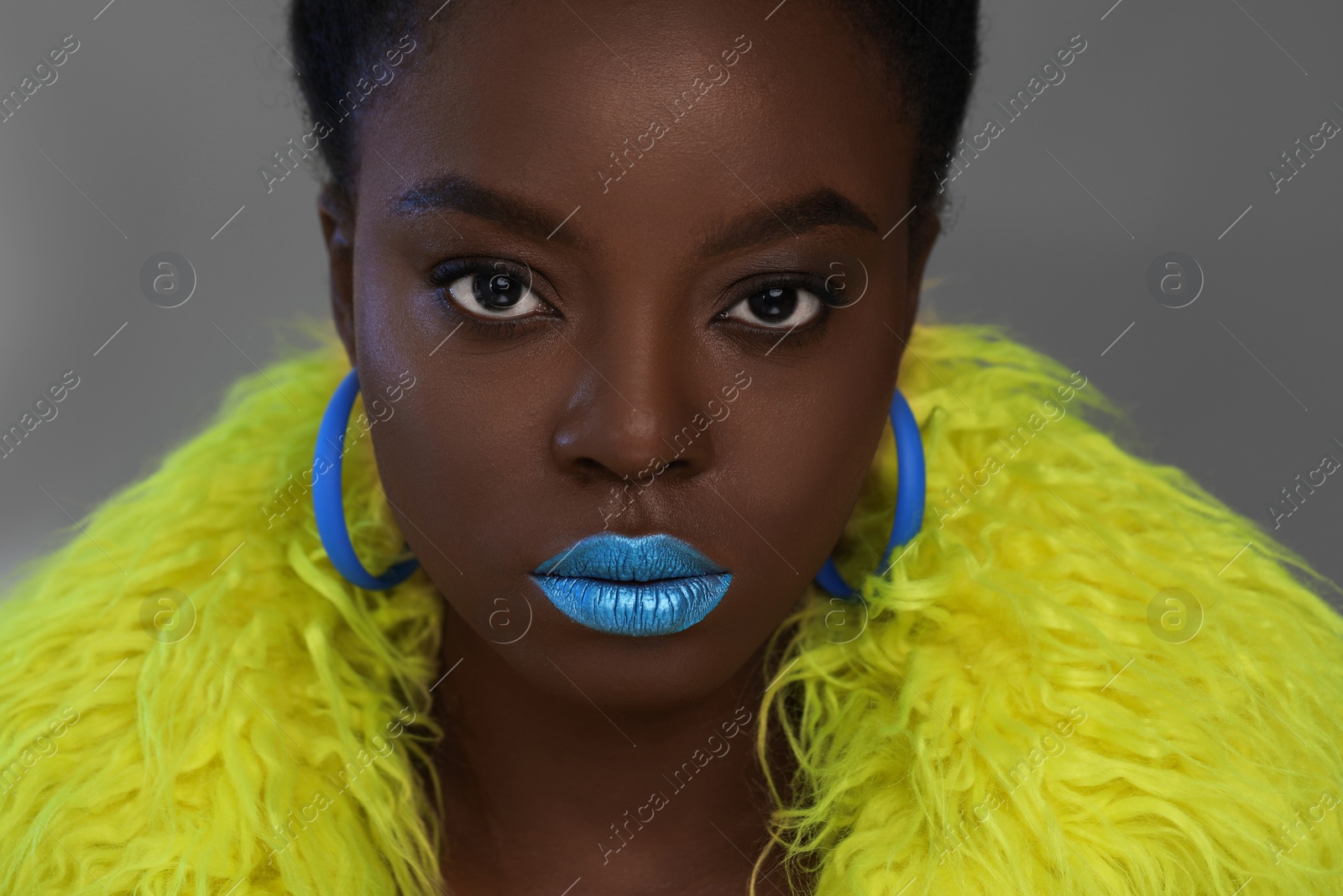Photo of Fashionable portrait of beautiful woman with bright makeup on grey background, closeup