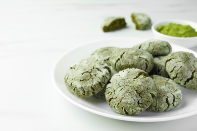 Plate with tasty matcha cookies on white table, closeup. Space for text