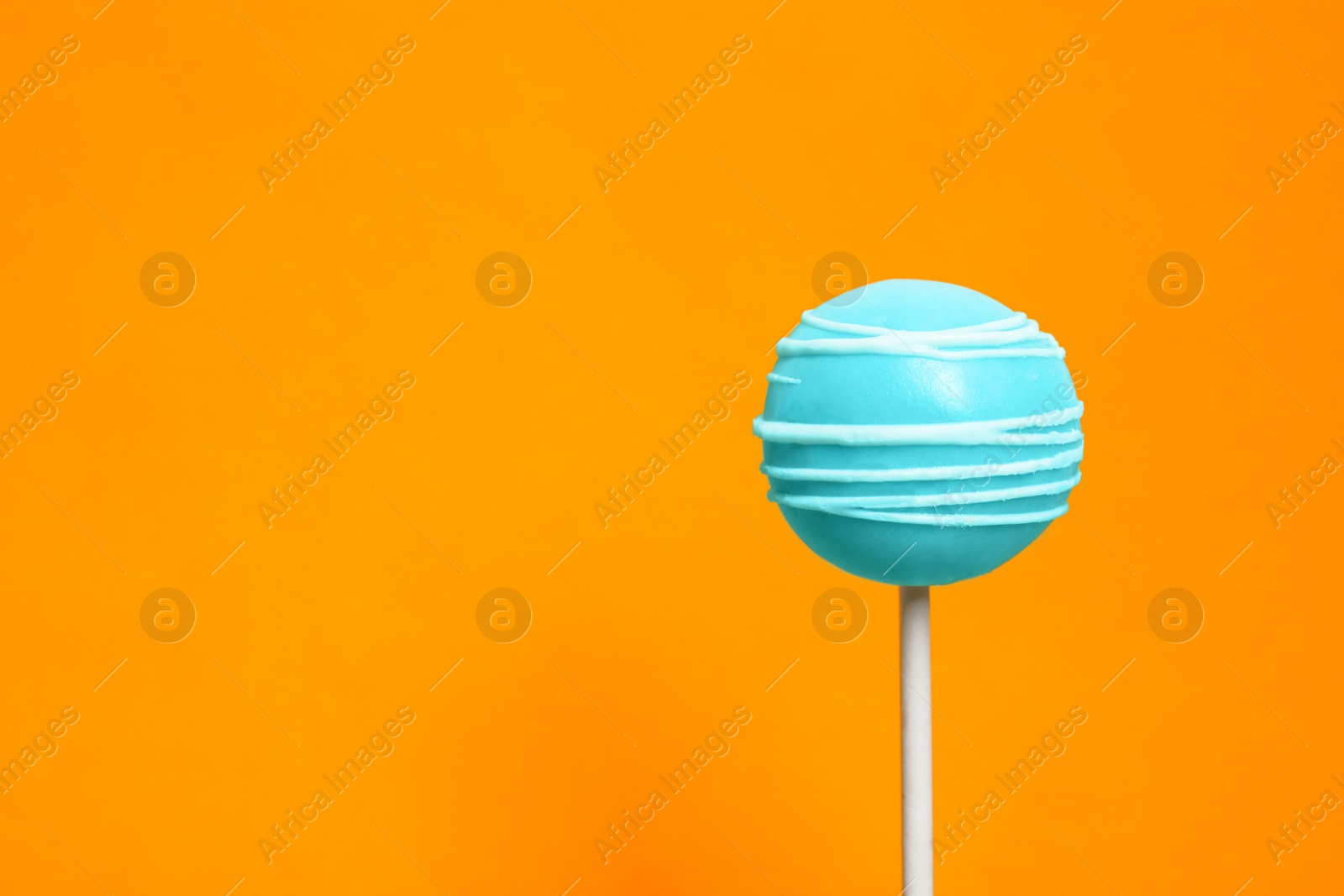 Photo of Bright delicious cake pop on color background. Space for text